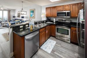 uma cozinha com armários de madeira e eletrodomésticos de aço inoxidável em Ariel Dunes I 507 Beach side resort em Destin