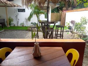 a wooden table with yellow chairs and a table with at Bungalow in El Nido