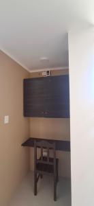 a desk in a room with a table and a shelf at Hotel Nueva Vista Huarmey in Huarmey