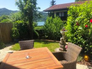 un tavolo in legno con due sedie e un bicchiere di Apartment SEEnsucht - Tolle Lage, nah am See, perfekt für Familien a Schliersee