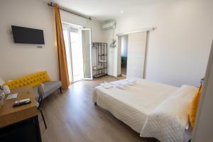 a bedroom with a bed and a couch and a table at Trapani Rooms 155 Self Check in in Trapani