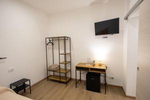 a room with a desk and a television on a wall at Trapani Rooms 155 Self Check in in Trapani