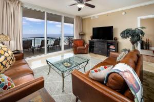 a living room with a couch and a television and a table at Bella Riva 301 Large Gulf Front condo in Fort Walton Beach