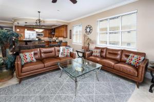 a living room with brown leather couches and a table at Bella Riva 301 Large Gulf Front condo in Fort Walton Beach