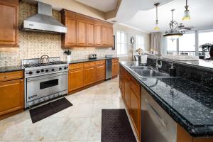 a large kitchen with wooden cabinets and stainless steel appliances at Bella Riva 301 Large Gulf Front condo in Fort Walton Beach +30 photos