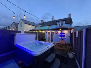 a bath tub sitting on the back yard of a house at Pauls Place in Brynsiencyn +29 photos