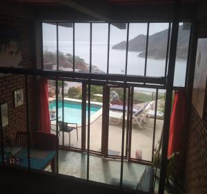 een raam met uitzicht op een zwembad bij Artists loft w panoramic views pool in Taganga