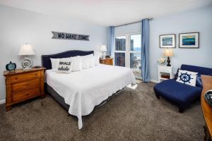 a bedroom with a large bed and a blue chair at Emerald Isle 610 Beach Front condo in Fort Walton Beach +30 photos