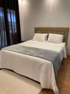 a bedroom with a large bed with white sheets and pillows at Quarto-Suíte Serra Petrópolis in Petrópolis +16 photos