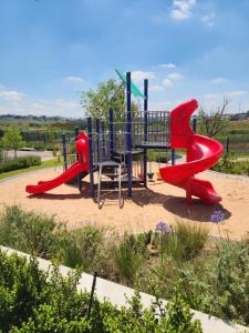 a playground with a slide in a park at The white house in Midrand