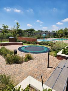 a trampoline on a brick patio in a garden at The white house in Midrand