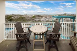 a table and chairs on a balcony with a view of the ocean at Gulf Dunes 106 Gulf Front condo in Fort Walton Beach