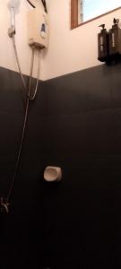 a bathroom with a phone and a toilet in the wall at Bungalow in El Nido