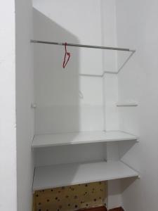 a white shelf in a room with a wooden box at Estancia Charito in Iquitos +1 photo