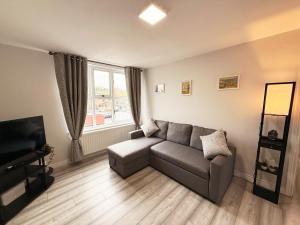 a living room with a couch and a television at 2 Bedroom City Centre Apartment By Travel Lets Short Term Rental Agency Derry With Free WiFi in Derry Londonderry