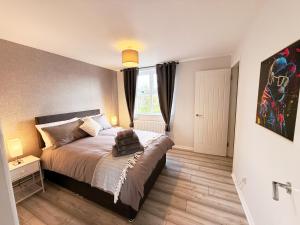 a bedroom with a large bed and a window at 2 Bedroom City Centre Apartment By Travel Lets Short Term Rental Agency Derry With Free WiFi in Derry Londonderry