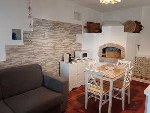 Eine Küche und ein Esszimmer mit Tisch und Kamin in der Unterkunft S' APPosenteddu in Baunei + 16 Fotos