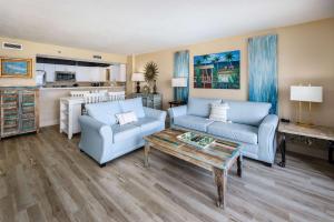a living room with two blue couches and a coffee table at Gulf Side 602 Pet friendly gulf front condo in Fort Walton Beach