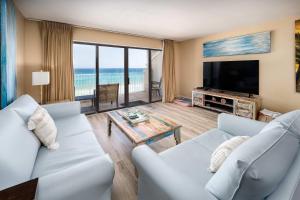 a living room with two white couches and a television at Gulf Side 602 Pet friendly gulf front condo in Fort Walton Beach