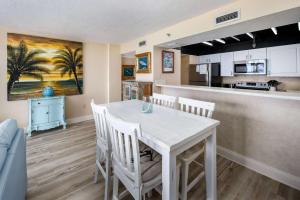 a kitchen and dining room with a white table and chairs at Gulf Side 602 Pet friendly gulf front condo in Fort Walton Beach +24 photos