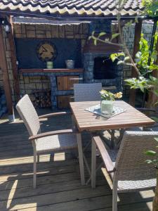 a wooden table and chairs on a deck with a fireplace at Charmante Fachwerkhaushälfte mit Sauna in Rosche