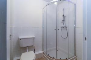 a bathroom with a shower with a toilet at Neat 2 bedroom ground floor flat in Beckenham
