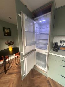 an empty refrigerator with its door open in a kitchen at One bed mews in Dublin