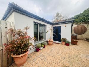 a house with potted plants on a brick patio at One bed mews in Dublin