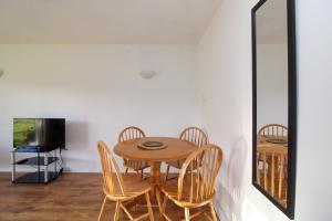 a dining room with a table and chairs and a mirror at Neat 2 bedroom ground floor flat in Beckenham