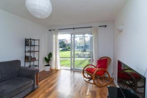 a living room with a couch and chairs and a window at Neat 2 bedroom ground floor flat in Beckenham +2 photos