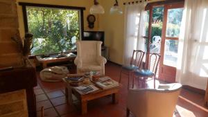 a living room with chairs and a table and a tv at Habitación en Casa de Campo La Alborada in El Bolsón