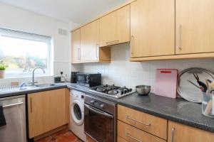 a kitchen with a stove and a dishwasher at Neat 2 bedroom ground floor flat in Beckenham