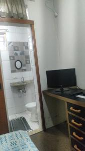 a bathroom with a desk with a computer and a toilet at Hotel Pousada Accordes in Campo Grande +16 photos