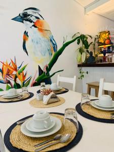 a dining room table with a bird on the wall at Pousada dos Pássaros Geribá in Búzios +43 photos