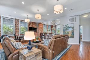 a living room with leather furniture and a brick wall at Home at 1014 in Savannah