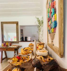 a table with several baskets of bread and a mirror at Pousada dos Pássaros Geribá in Búzios
