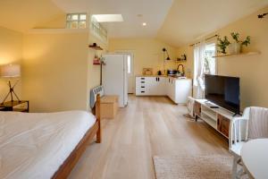 een slaapkamer met een bed en een keuken bij Pacific View Cottage - 100 High with Ocean Views in Langlois