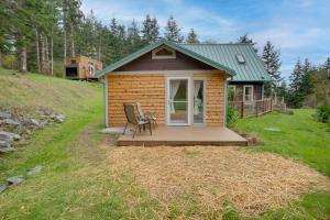 een tiny house met een stoel op een terras bij Pacific View Cottage - 100 High with Ocean Views in Langlois