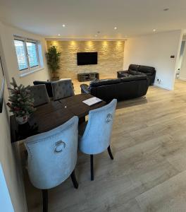 een woonkamer met een tafel, stoelen en een bank bij KM Granton Apartment in Edinburgh