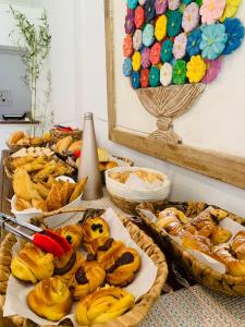 uma mesa coberta com diferentes tipos de doces e tortas em Pousada dos Pássaros Geribá em Búzios mais 43 fotografias