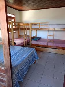 a room with two bunk beds and a table at CASA de 02 suítes e 1 quarto, piscina e churrasqueira "casa maré alta" in Barra de São Miguel