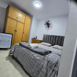 a bedroom with a large bed and a fan at Cozy Private Studio DBL in ‘Ezbet `Abd el-Ḥamîd