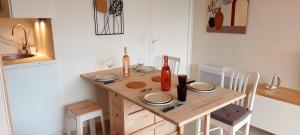 una pequeña cocina con mesa de madera y sillas en Appartement Port Santa Lucia, en Saint-Raphaël