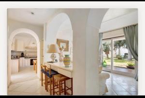 a kitchen and living room with white walls and a table at Villa Liuba con piscina in Forio d'Ischia