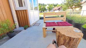 a bench with pink pillows on it on a porch at Sofia apartman in Kolašin