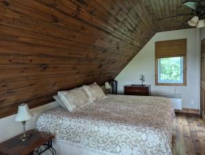 una camera da letto con un letto e un soffitto in legno di Eagle Nest Cottage a Val des Monts