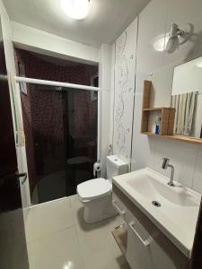 Un baño blanco con inodoro y lavabo. en Apartment 2 minutes from the beach, en Itajaí
