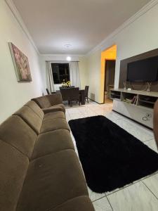 una sala de estar con un sofá y un televisor en Apartment 2 minutes from the beach, en Itajaí 4 fotos más
