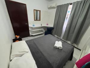 Una habitación de hospital con una cama con zapatos blancos encima. en Apartment 2 minutes from the beach, en Itajaí