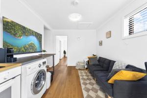 Una sala de estar con un sofá y una cocina. en Charming Haven, peaceful stay, en Castle Hill